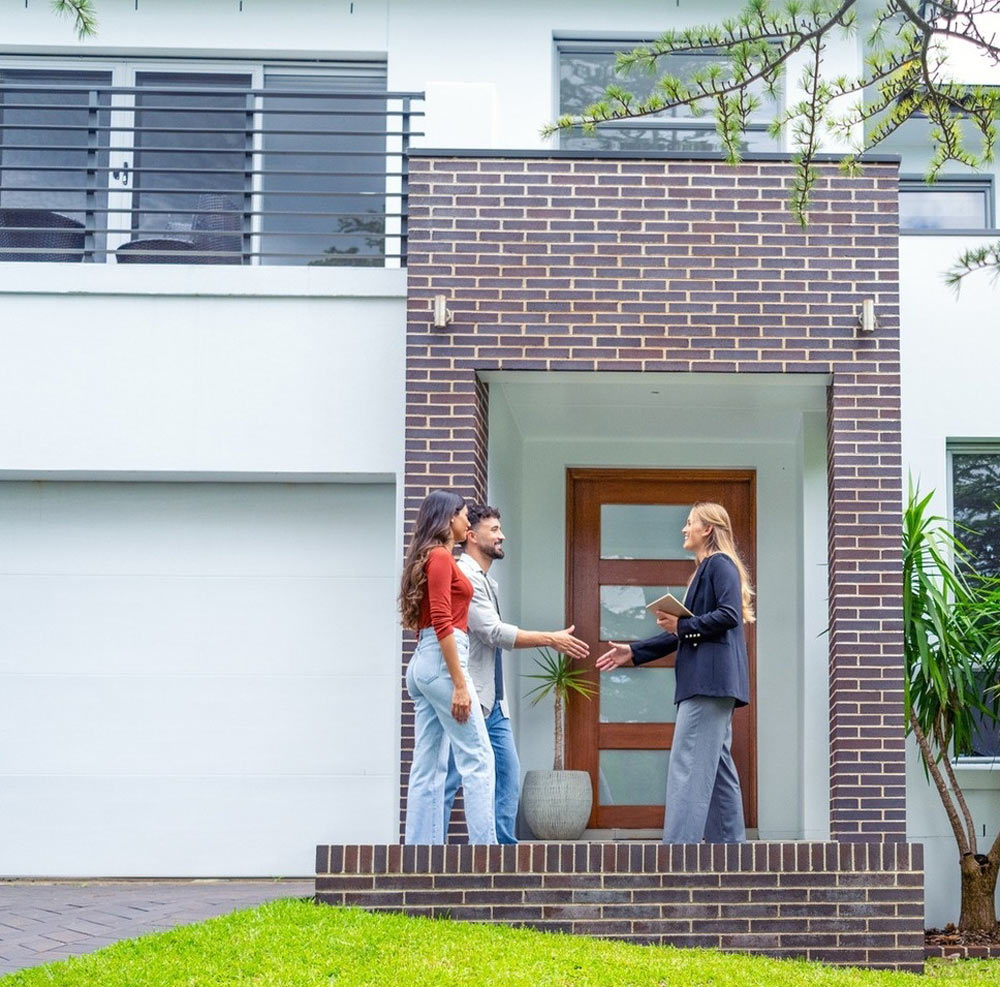 Young Couple Shaking Hands With A Property Manager